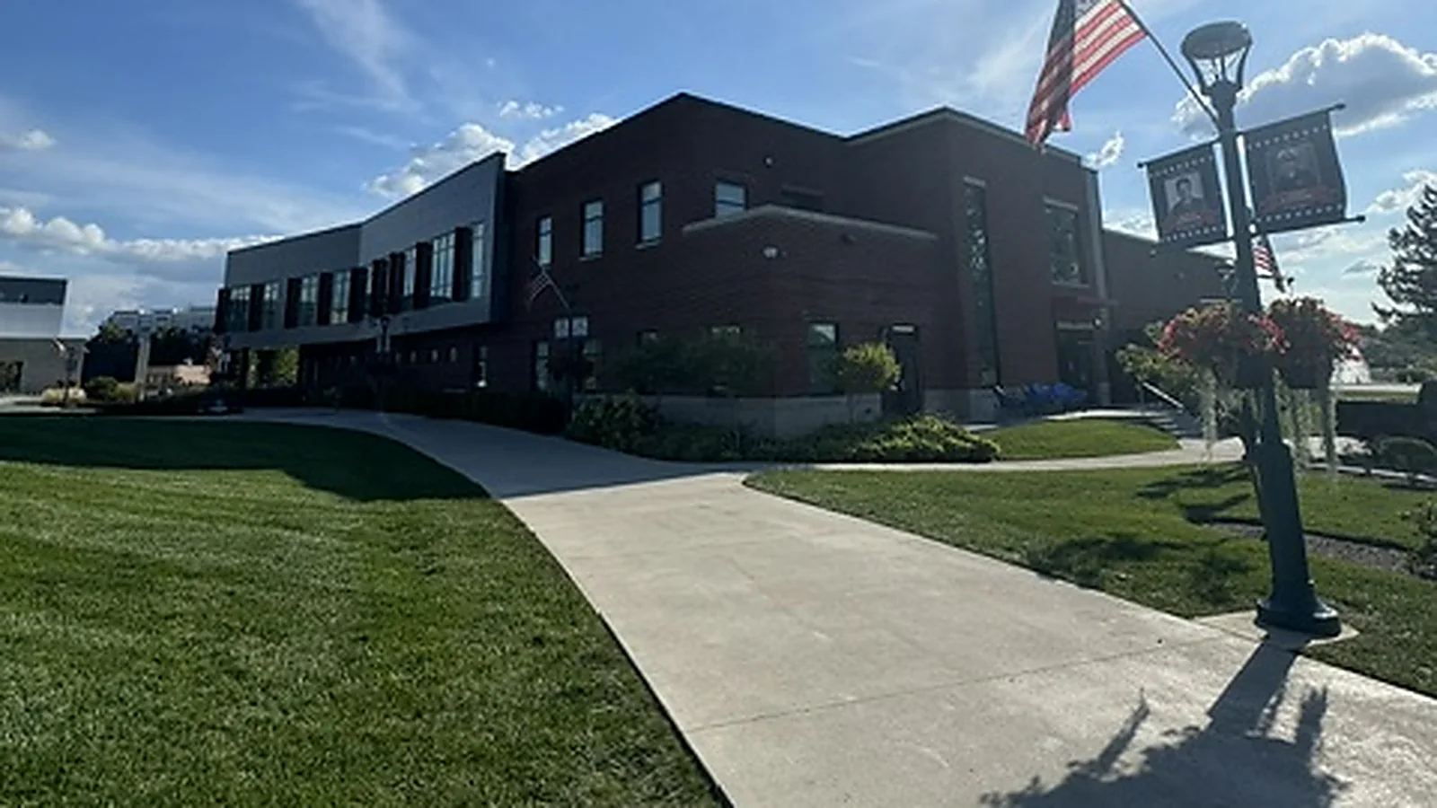 A modern brick and metal civic building in Fishers with banner lined walkways