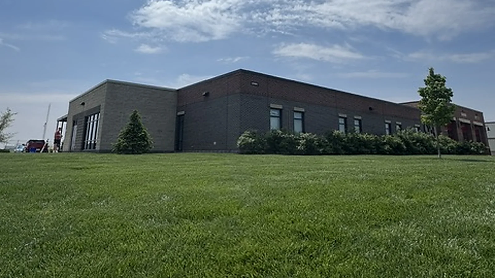 A Fishers fire station with apparatus bay doors seen across the lawn