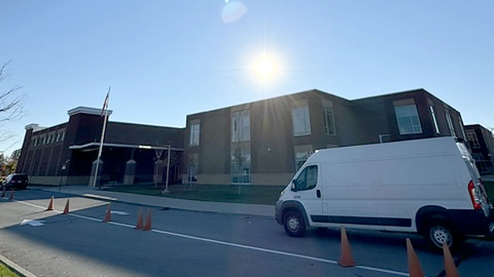 A Hamilton Southeastern school building with a Walden van and cones set out in the parking lot