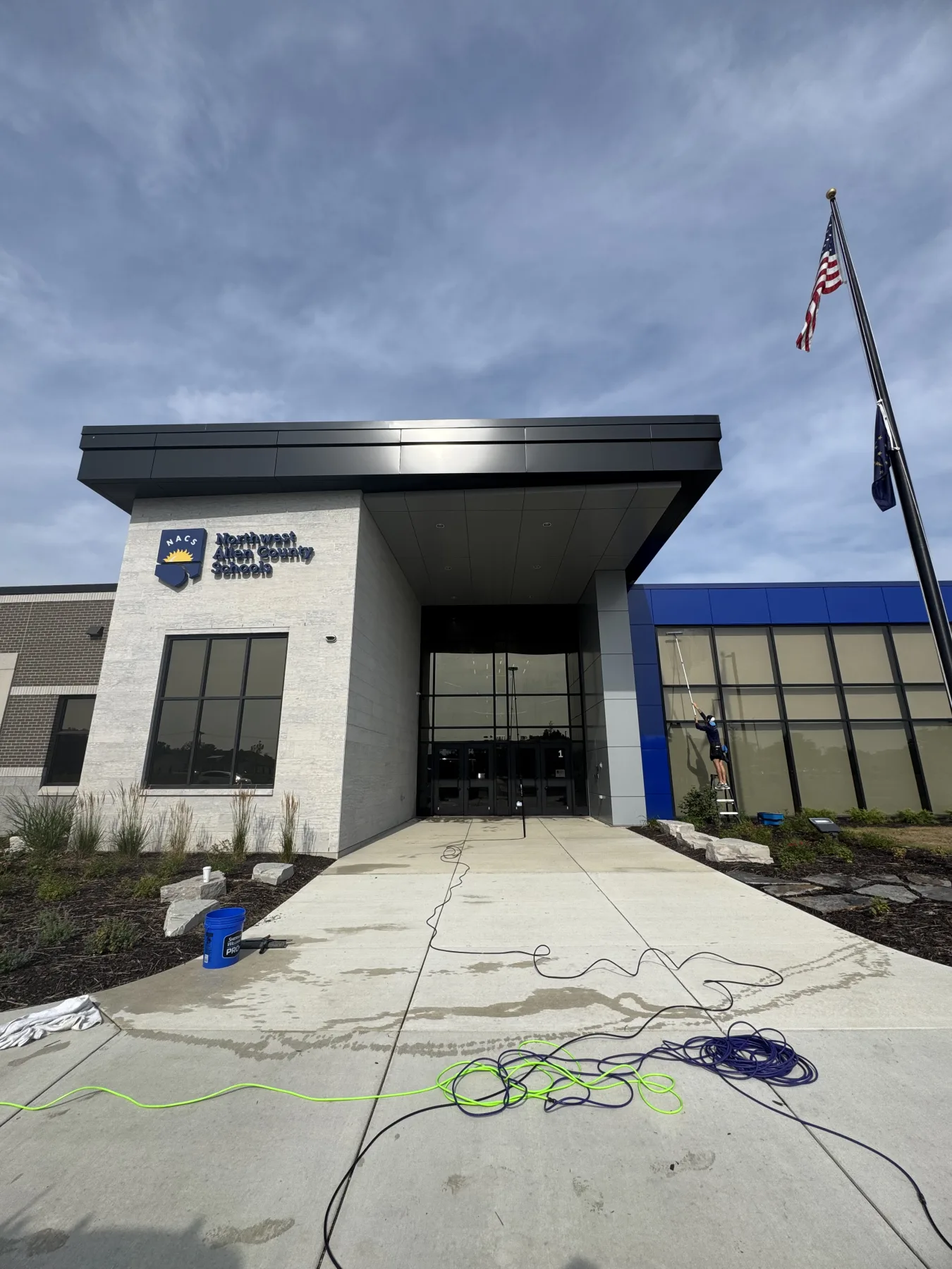 Walden technician cleaning entrance glass at a Northwest Allen County Schools building